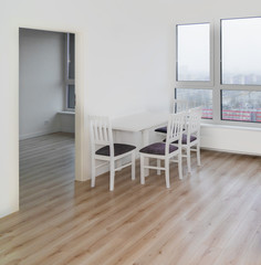 White table and chairs in a white  room