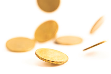 The antique aged gold coin falling down on bright background