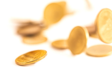The antique aged gold coin falling down on bright background