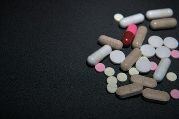 Grupo de pastillas y píldoras en fondo negro
