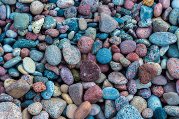 Kolorowe granitowe kamienie otoczaki na plaży. 