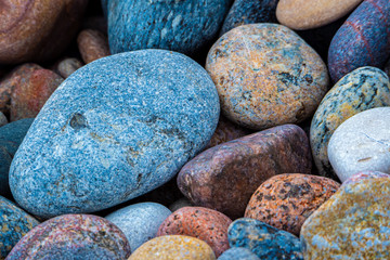 Kolorowe granitowe kamienie otoczaki na plaży. 
