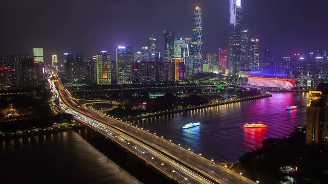 Guangzhou night business city aerial cityscape China Pearl river with boats traffic and bridges timelapse pan up
