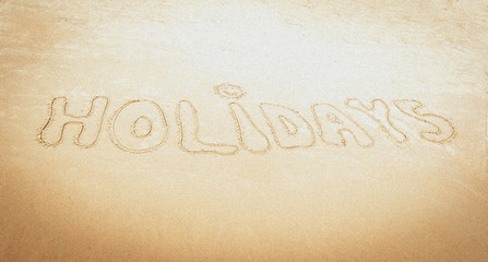 Odręczny napis holidays - wakacje  na piasku nad morzem