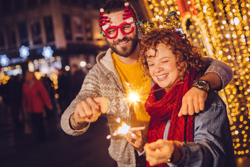 Obraz na płótnie Canvas Couple with sparklers celebrating new year
