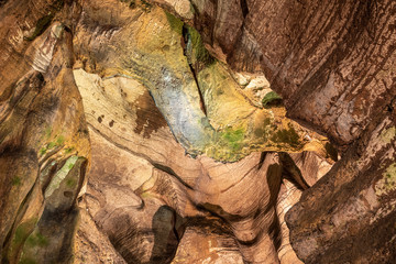 View inside the ancient cave with stone walls with additional lighting. Texture of a stone wall in a cave.