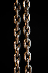 Rusty chains weathering. Chain on black background.