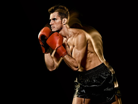 one caucasian young man boxer boxing profile side view in studio isolated on black background
