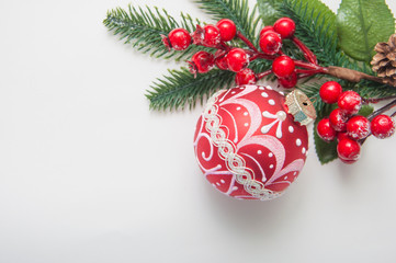 Christmas balls and berries on white table top view.