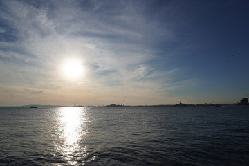 Obraz premium sunset over the sea statue of liberty 