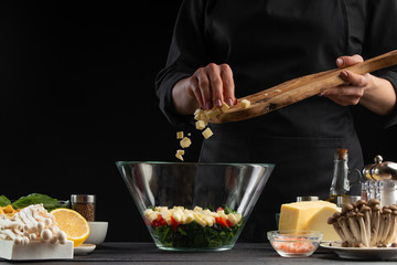 Chef sprinkles squares of mazarella cheese in a bowl with salad,. Freeze in motion, Salad, organic ingredients and products. Vegetarian and tasty food. Advertising photo of food
