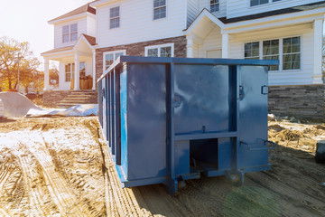 Blu dumpster, recycle waste and garbage bins near new construction site of appartment houses building
