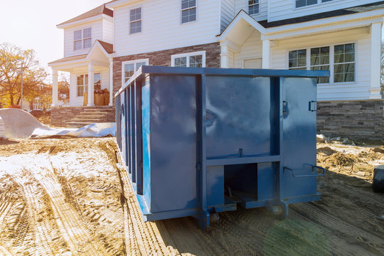 Blu dumpster, recycle waste and garbage bins near new construction site of appartment houses building