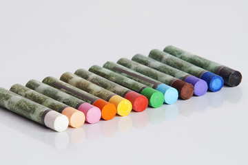 Naklejka premium The color scheme of pastel sticks with reflection on the white surface of the school table - education, art, creativity, return to school.