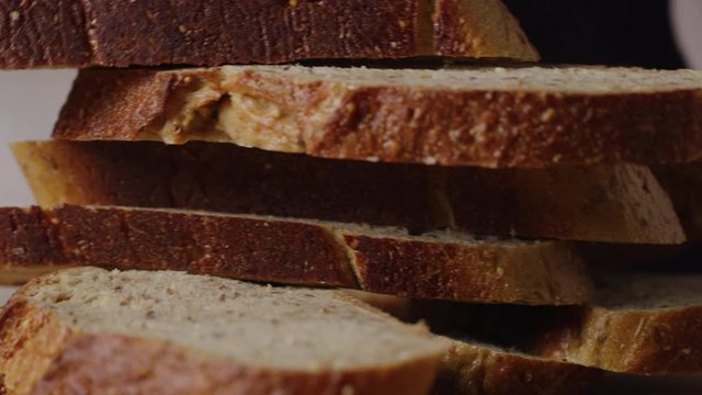 Slicing brown bread macro shot, cooking toasted bread, slow motion, shot on Red Weapon Helium