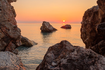 Fototapeta na wymiar orange dawn in the early morning on the sea rocky shore