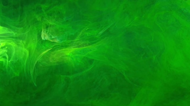 saturated emerald and lime green color acrylic ink flowing and swirling into water, heavily pigmented and beautiful colors make for pretty multi colored clouds for background footage and effects.