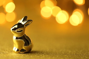 Easter bunny. Golden easter metallic bunny on golden glitter background .Easter festive shiny background