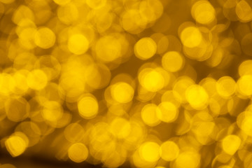 Defocused of blurred golden bokeh circle light from lighting bulb Merry Christmas and Happy New Year decorative in the night for abstract background texture