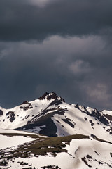 Snowy mountains peaks with dark clouds in the background. Loveland Pass, Colorado