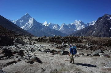 Fototapeta premium Everest trek, Man hiking in Himalayas with view of Ama Dablam mountain. Sagarmatha national park, Solukhumbu, Nepal