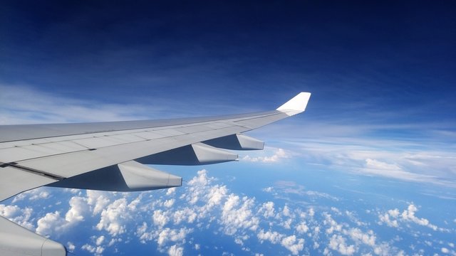 Wing of an airplane flying above the clouds