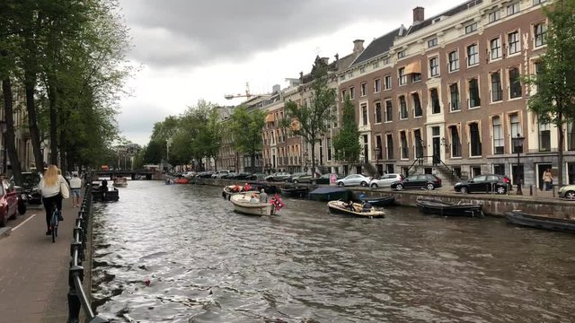 AMSTERDAM - OCTOBER 6, 2019: 4K UltraHD DX daytime Establishing shot of amsterdam canal with boats