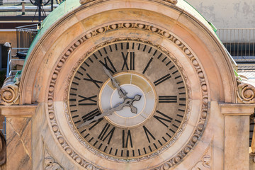 Fototapeta na wymiar Clock on top of building behind of Duomo di Milano