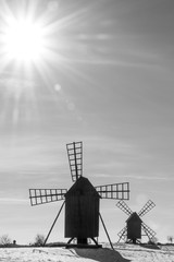 Sun and sunbeams by two old windmills