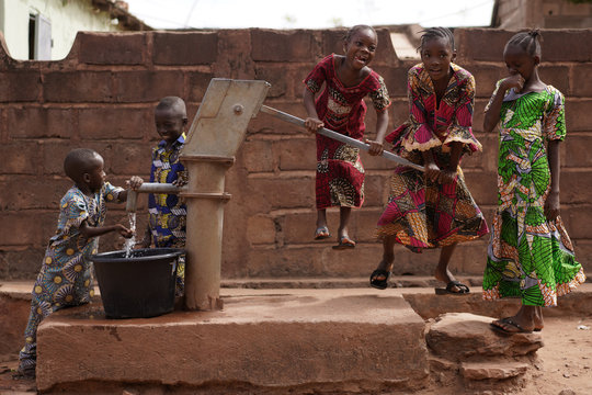 African Children Having Fun While Taking Water From A Hand Pump