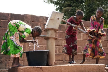 Foto op Canvas African Children At A Public Borehole Fetching Water For Their Families © Riccardo Niels Mayer