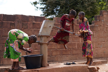 African Girls At A Public Borehole Pump Running Out Of Water