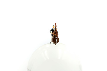 Miniature people : pianist playing piano and Violinist Man with mini world glass,playing musical instrument concept.