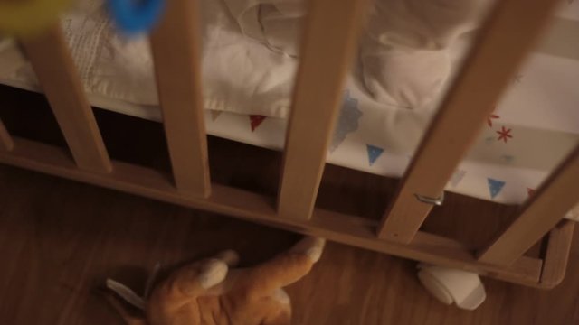 Baby in a crib, wooden cot.