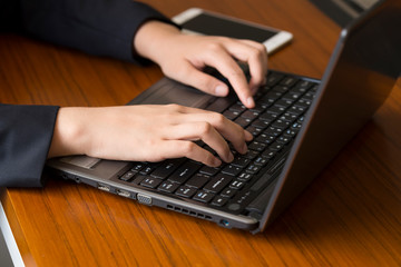 A businesswoman USES a laptop in her office.