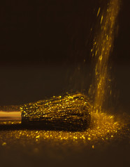 texture of gold glitter on the makeup brush and design. On a black background. Selective Focus