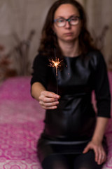 Obraz na płótnie Canvas Girl holds sparkler in her hands, soft focus