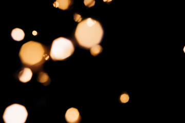 Golden abstract bokeh sparkle on black isolated background. Holiday concept. Place for design. Festive concept.