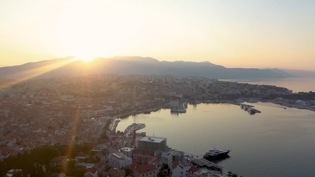 Rising aerial shot from Marjan Forest Park overlooking the harbor of Split City at sunrise