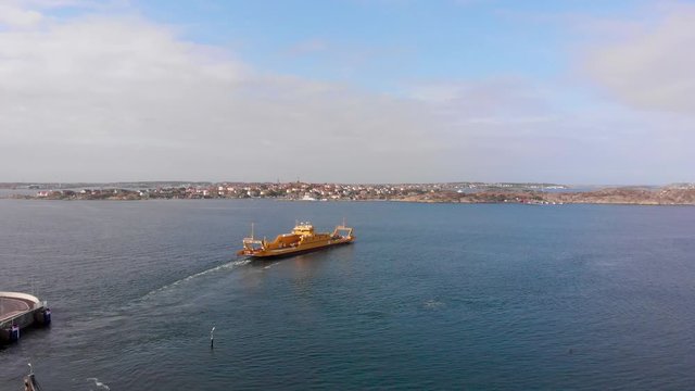 Aerial Pedestal Shot of Orange Ferry in Gothenburg, Sweden during sunny day. Water is blue