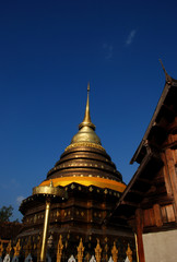 Naklejka premium Golden Pagoda with blue sky, Phra That Lampang Luang.
