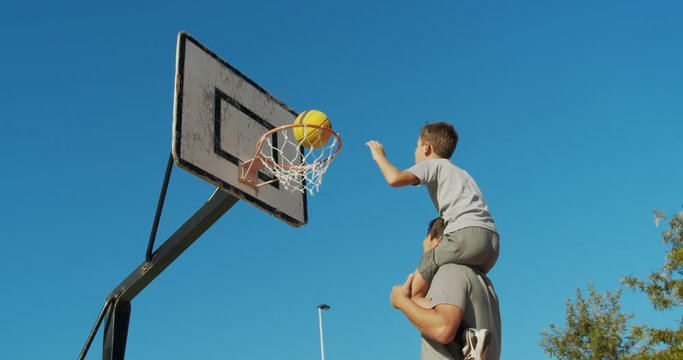 Father and son enjoy a playing basketball.