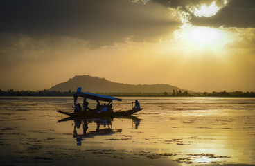 A wooden boat in Dal Lake, Srinagar, Kashmir on a sunset