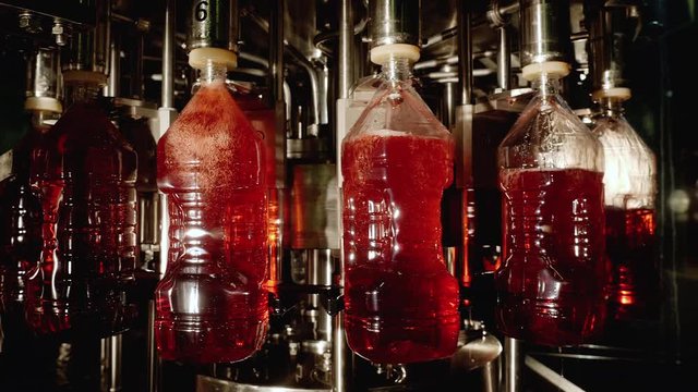 Industrial production line for bottling and packaging liquids. Automation of the food industry, concept of a bottling plant. Factory of manufacturing fresh beverages, wine, juices on conveyor line.