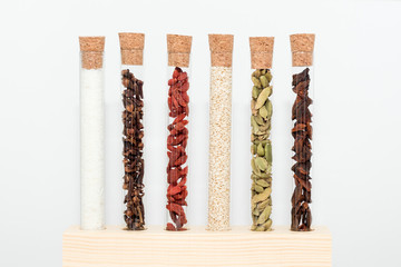 Various spices in glass flasks. Homemade spices ingredients for cooking, cardamom, coconut, cloves, star anise, goji berries.