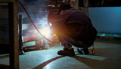 Fototapeta premium Worker doing spot welding in dim workshop