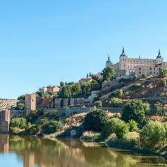 Fototapeta premium view from the river bank on the fortress wall and castles of the ancient Spanish city of Toledo