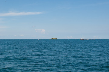 A seascape. A small island with a lighthouse and yachts in the Adriatic Sea near Rovinj. Croatia. Istria