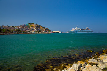The marina in Kusadasi. The coast and port in the city, fishing boats and tourist ship. Place of holiday photos.