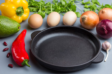Frying pan. A set of vegetables for a healthy diet, eggs, peppers, tomatoes, onions, garlic, avocado. .